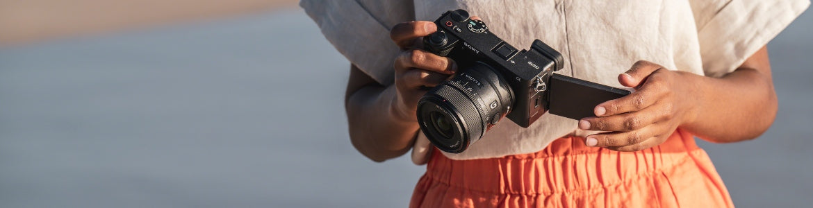 Sony APS-C camera comparison - person holding Sony A6000 series camera